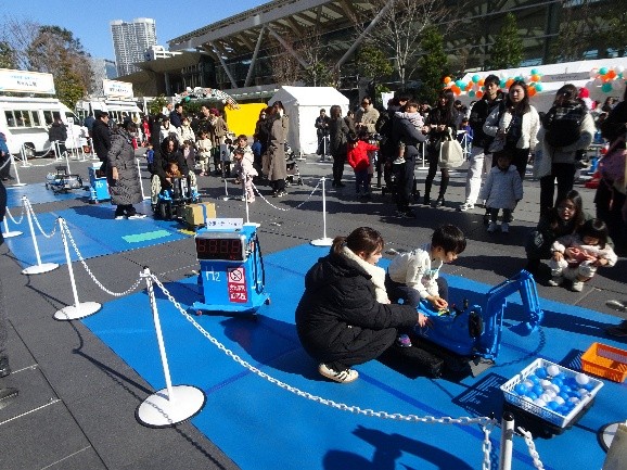 水素で作ったエネルギーで動く遊具で遊ぶ子どもたちの様子